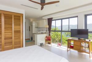 拉迈Awesome sea view pool studio B - 2 people - Lamai Bay View - Koh Samui的一间卧室，配有一张床和一张带电视的书桌