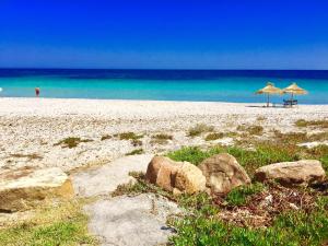 due ombrelloni e sedie su una spiaggia con l'oceano di Casa del Mar Residence a Kelibia