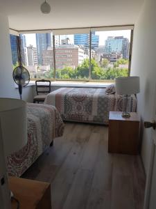a bedroom with two beds and a large window at Lindo departamento a pasos del Centro comercial Costanera Center in Santiago +58 photos