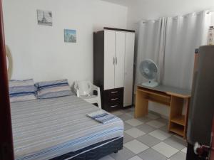 a bedroom with a bed and a desk with a fan at FARO FINO 104 DISNEY in Goiânia