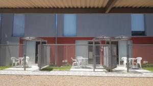 a group of white chairs and tables on a building at Lugones in Ezeiza