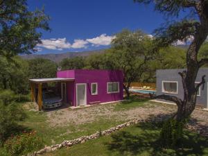 una casa púrpura con un coche aparcado delante de ella en Entre Sierras y Pajaros en Las Rabonas