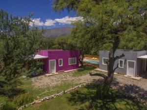 a home with a purple and white house at Entre Sierras y Pajaros in Las Rabonas