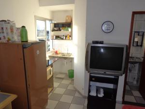 a living room with a television and a kitchen at FARO FINO 104 DISNEY in Goiânia