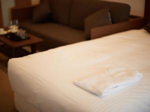 a close up of a bed with a towel on it at Creass Hotel Tsubogawa Marche in Naha