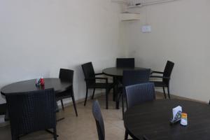 a dining room with black tables and chairs at Hotel Raj in Aurangabad