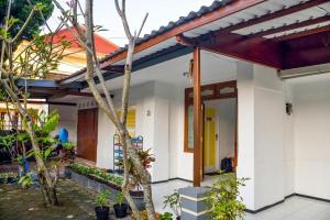 a house with a courtyard with trees in front of it at Rumah Larasati in Malang