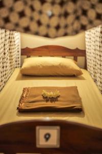 a couple of beds with a towel on top of it at Rumah Larasati in Malang