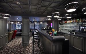 - un bar avec un comptoir et des tabourets dans une pièce dans l'établissement Hotel le Cinq Hyper - Centre, à Chambéry