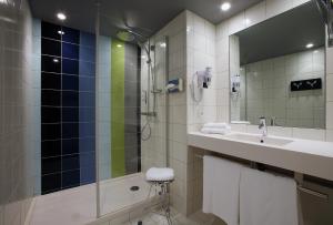 ein Badezimmer mit Waschbecken und Dusche in der Unterkunft Hotel le Cinq Hyper - Centre in Chambéry + 26 Fotos
