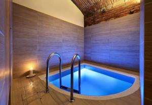 a hot tub in a bathroom with wooden flooring and a room with at Absolutum Wellness Hotel in Prague