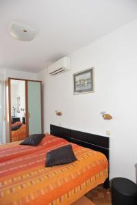 ein Schlafzimmer mit einem großen Bett mit einer orangefarbenen Decke in der Unterkunft Zadar Old Town Apartments II in Zadar