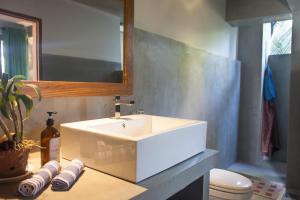 a bathroom with a white sink and a toilet at Serene Villa in Hiriketiya