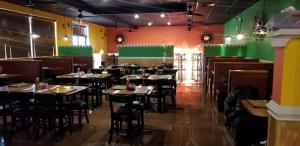 un restaurante con mesas, sillas y paredes verdes en Americas Best Value Inn Hamilton, en Hamilton