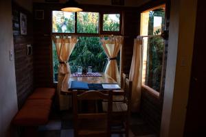 una mesa pequeña en una habitación con 2 ventanas en Patagonia Retro en Esquel