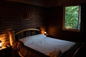 1 dormitorio con cama de madera y ventana en Patagonia Retro en Esquel