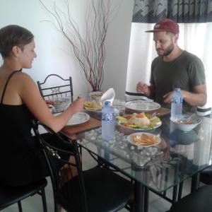 a man and a man sitting at a table with food at Reshani Guest House in Negombo