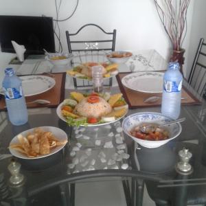 a table with plates of food and bottles of water at Reshani Guest House in Negombo
