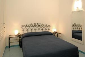 a bedroom with a black bed with two night stands at Aurora Apartments in Amalfi