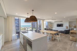 a kitchen and living room with a view of the ocean at Astina Suites, Forster in Forster