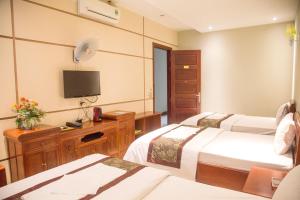 Cette chambre comprend deux lits et une télévision. dans l'établissement Khách Sạn Hoàng Gia Lào Cai - Hoang Gia Hotel, à Lào Cai