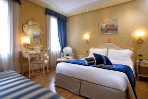 威尼斯Hotel Olimpia Venice, BW Signature Collection 3sup的配有一张大床和一张书桌的酒店房间