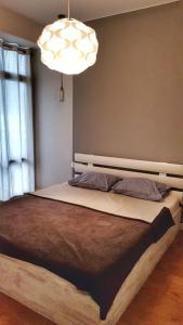 - une chambre avec un grand lit et un lustre dans l'établissement Your Home in Tbilisi: Cosy stay in the Old City, à Tbilissi