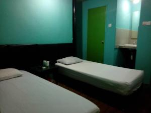 a room with two beds and a bathroom with a mirror at Petaling Street Hotel Chinatown in Kuala Lumpur