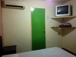 a green door in a room with a tv at Petaling Street Hotel Chinatown in Kuala Lumpur