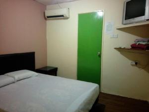 a room with a green door and a bed at Petaling Street Hotel Chinatown in Kuala Lumpur
