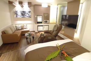 a living room with a couch and a flat screen tv at Hotel GOLF Nirasaki (Adult Only) in Nirasaki