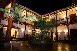 a building with palm trees in a courtyard at night at La Casona Monsante in Chachapoyas