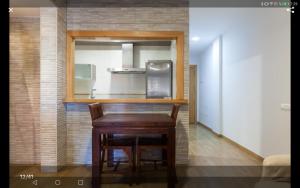 a kitchen with a wooden table and a refrigerator at Calle Austria in Roquetas de Mar