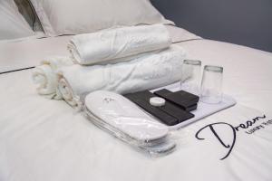 een dienblad met handdoeken en andere artikelen op een bed bij DREAM LUXURY HOTEL in Muar