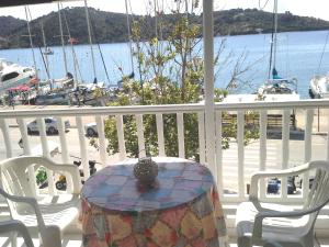una mesa y sillas en un porche con vistas al agua en Skiathos city views studios-apartments en Skíathos