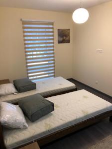 three beds in a room with a window at Poilsio apartamentai "Jolita" in Druskininkai