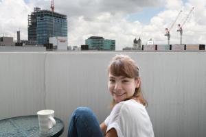 een meisje op een richel met een kop koffie bij IBASHO ShibuyaDogenzaka907 in Tokyo