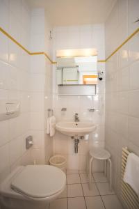 biała łazienka z umywalką i toaletą w obiekcie Hôtel Résidence Cité-Verdaine w Genewie