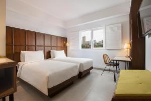 Un pat sau paturi într-o cameră la Kampi Hotel Tunjungan - Surabaya