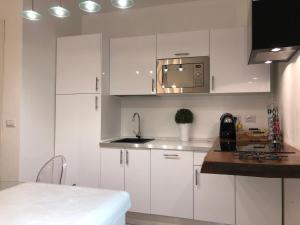 a kitchen with white cabinets and a sink at Domus Antiqua San Lorenzo in Genoa