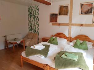 ヘーヴィーズにあるKaktusz Villa Hevizのベッドルーム1室(ベッド2台、緑のタオル付)