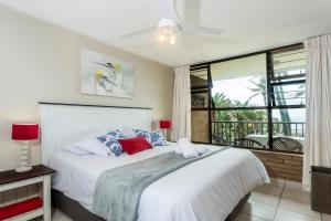 a bedroom with a bed and a large window at 33 Boulder Bay, Ballito in Ballito