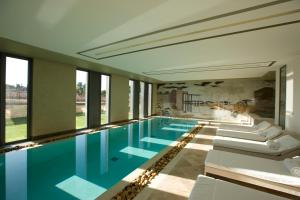 a swimming pool in a building with windows at Domaine de Verchant & Spa - Relais & Châteaux in Montpellier