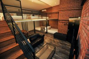 a loft room with a couch and a bed at Iconic Suites & Pods Hotel in Ipoh