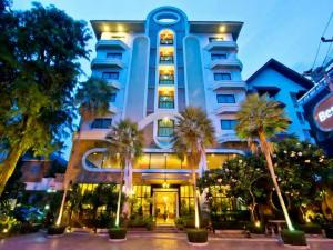 een groot gebouw met palmbomen ervoor bij Best Beach Villa in Pattaya