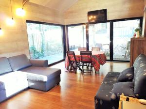 a living room with a couch and a table and chairs at BELLEVUE Maison Atypique Grande Terrasse au Calme in Pyla-sur-Mer +4 photos