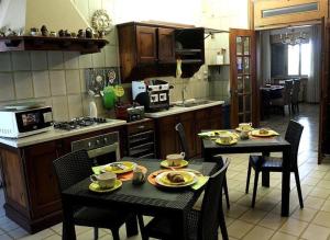eine Küche mit zwei Tischen und Stühlen mit Essen drauf in der Unterkunft B&B Villa Elvira in San Vito