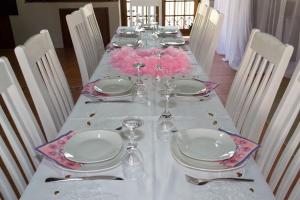 a long table with white plates and wine glasses at Tuscany Vryburg in Vryburg