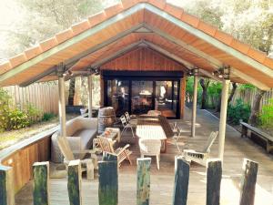 a wooden gazebo with a table and chairs at BELLEVUE Maison Atypique Grande Terrasse au Calme in Pyla-sur-Mer