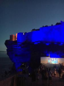 a group of people standing in front of a building at night at Hotel Les Chambres de Mila Bonifacio in Bonifacio